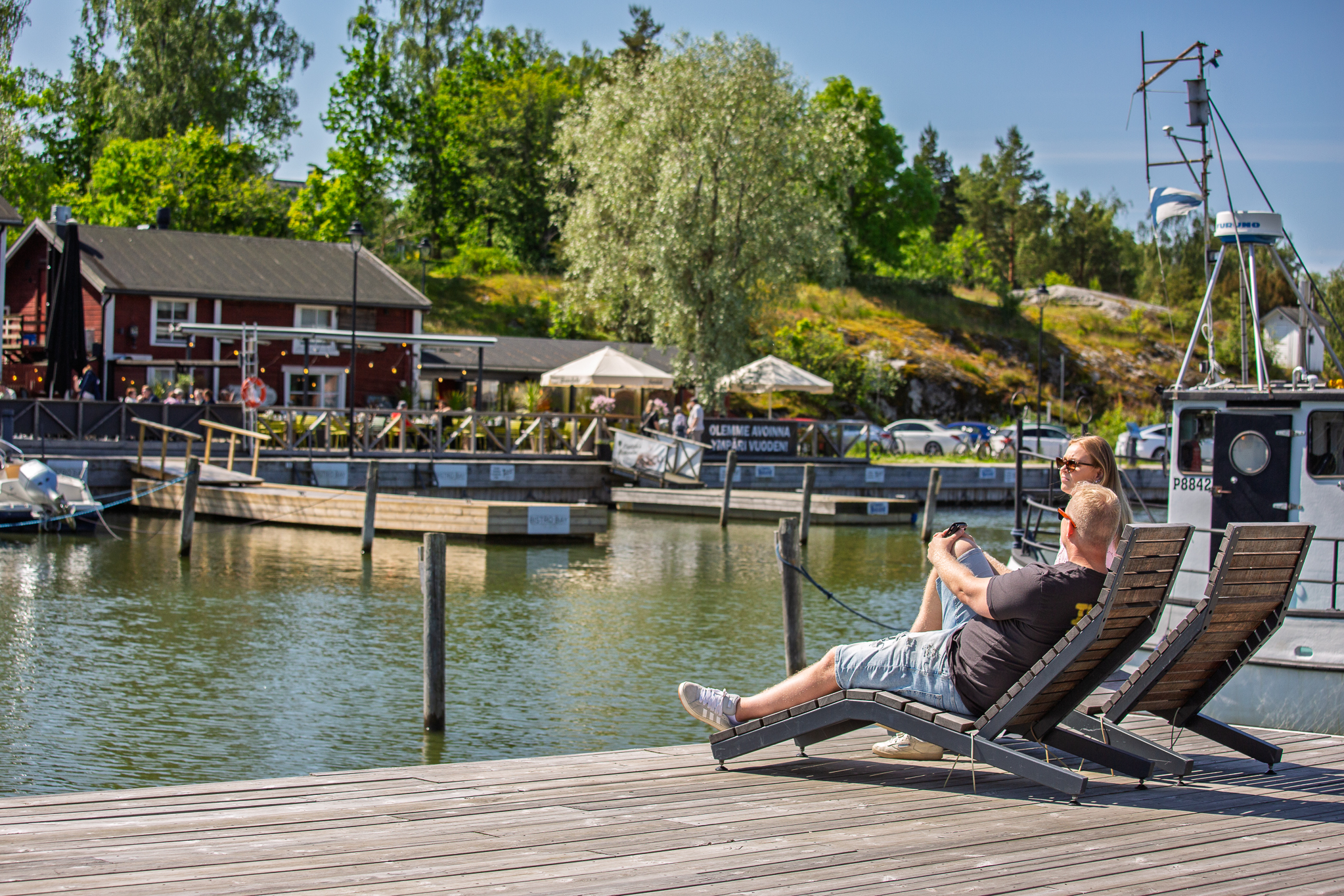 Tuoleissa istujat rannalla