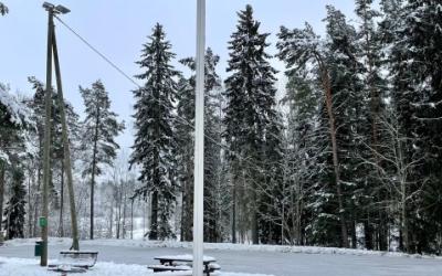 Luistelukentän edessä leikkipuisto, takana metsikkö