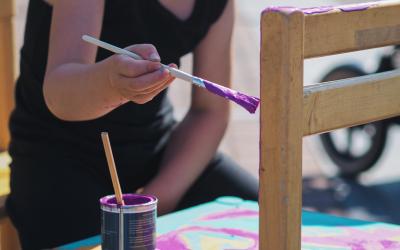 Lapsi maalaa vanhaa puutuolia.