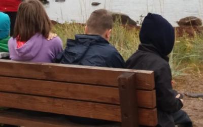 Tukiluokan oppilaita meren rannalla.