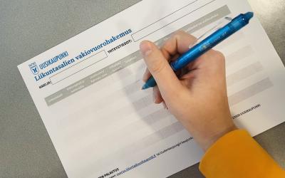 vakivuorohakemuskaavaketta täyttämässä, kädessä kynä