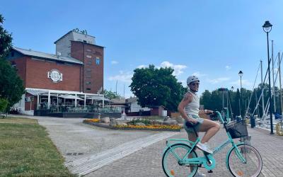 nainen pyörän kanssa kaupungin rannalla