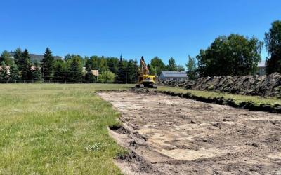 Kaivuri kaivaa Pietolan pallokentän vihertävää nurmikkoa pois kauniissa kesäilmassa.