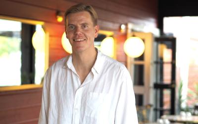 Niko  Kluuskeri valkoisessa paitapuserossaan Bistro Bayn terassilla.