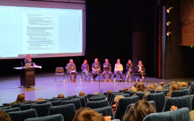 Juontaja ja lasten parlamenttiin osallistuvat keskustelijat rivissä vierekkäin kulttuurikeskus Crusellin lavalla.