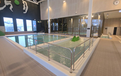 Uimahallin lastenaltaita. Edessä matalampi allas pienellä liukumäellä ja takana syvempi lastenallas.