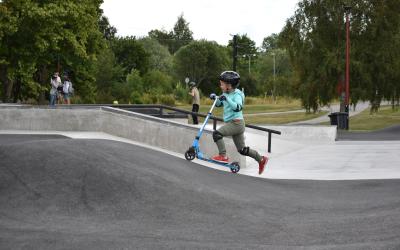 Pumptrack-rata, pieni poika skuutin kanssa.