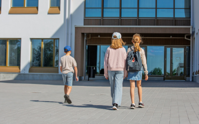 Kaksi tyttöä ja yksi poika kävelee kohti Wintterin koulurakennuksen sisäänkäyntiä. 