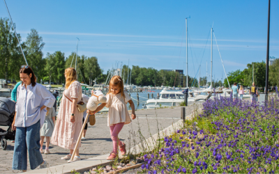 Naisia ja lapsia kävelemässä Uudenkaupungin kaupunginlahden rannalla kesäpäivänä.