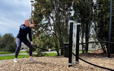 nainen treenaa ulkona voimaköysien kanssa