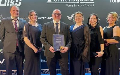 urheilugaalassa ihmiset poseeraavat palkinnon kanssa