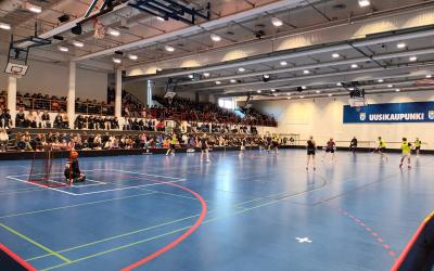 liikuntasalissa pelataan salibandyä taustalla katsomo