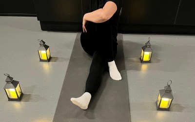 liikunnanohjaaja tunnelmavalossa istumassa lattialla