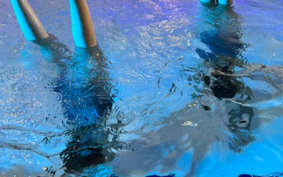 Lapset käsilläseisonnassa uima-altaassa