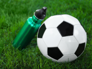 Jalkapallo ja juomapullo tekonurmella.