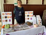 nainen esittelee tiskin takana rintasyöpätietoutta