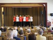 Seniorimessuilla senioritanssiesitys lavalla, etualalla yleisöä.