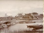 Kaupunkikuva, kuvattu Kainpirtin suunnasta kohti kaupunkia. Etualalla ns. Pitkäsilta, Baltzarborgin asuinaluetta, sitten Vallimäki, jossa ravintola Vallila, puinen keilaratararakennus ja luotsiasema. Uuden ja vanhan kirkon tornit näkyvissä. Veneitä rannassa.