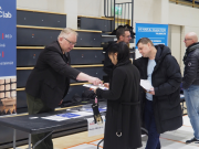 Mies ojentaa esitteen naiselle.