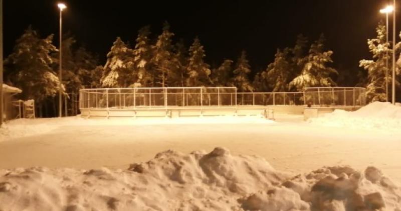 Etualalla luistelukenttä, taustalla luistelukaukalo, talvinen iltakuva