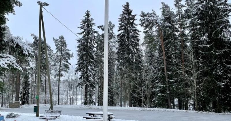 Luistelukentän edessä leikkipuisto, takana metsikkö