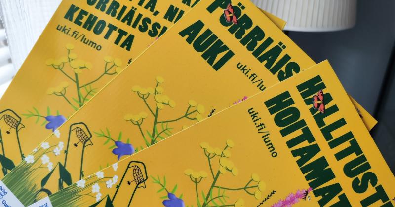 Kuvassa kotipihoille tarkoitetut lumokyltit. Värikkäät kyltit jotka kertovat pihan luonnon mukaisuuden eteen tehtävistä toimista