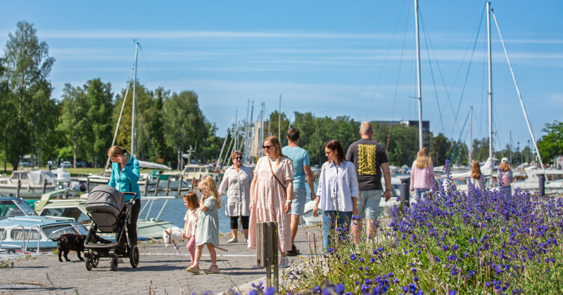 Ihmisiä kävelemässä kesällä Kaupunginlahden rannalla.