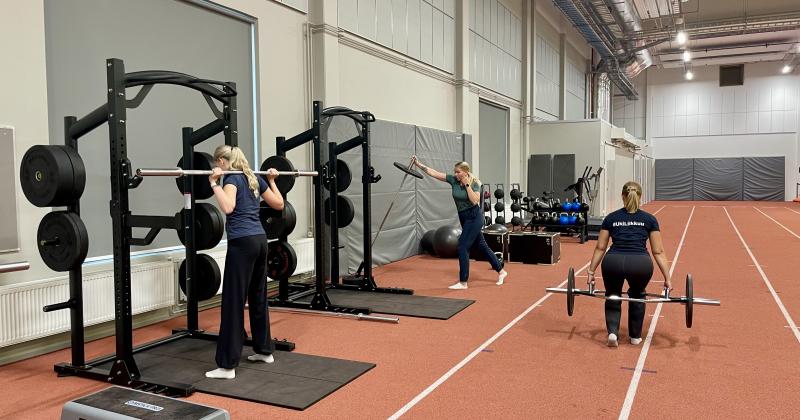 naisia treenaamassa yleisurheilutilassa