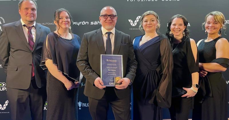 urheilugaalassa ihmiset poseeraavat palkinnon kanssa