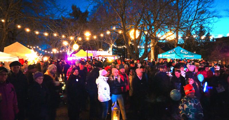 Ihmisiä katsomassa Hehkun ohjelmaa valaistussa Rauhanpuistossa.