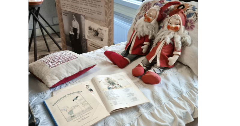 vanhat tonttunuket museossa sängyn päällä.