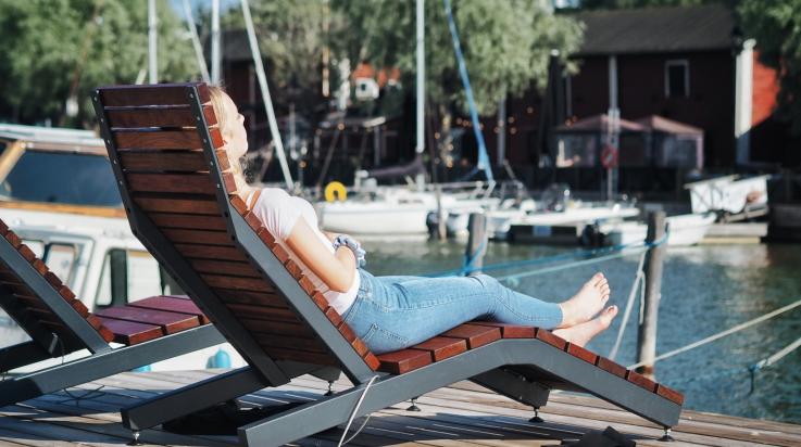 Tyttö kaupunginlahden rannalla tuolissa