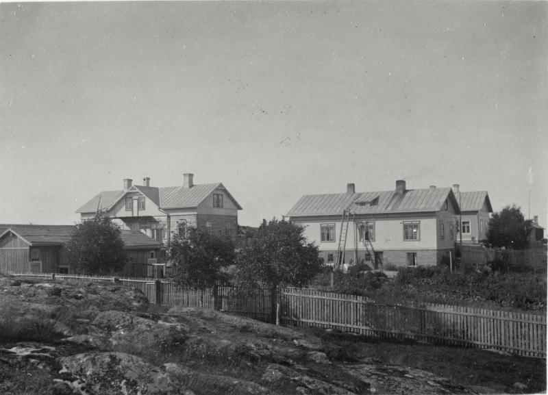 Maisemakuva kukonmäeltä. Kuvan lähde Finna/ Uudenkaupungin museo. Kukonmäki, kuvattu Kukonmäen kalliolta kohti pohjoista. Kaksi puurakennusta (Merimiehenkatu 28 ja 30). Etualalla kalliota, aita ja talojen puutarhaa. 