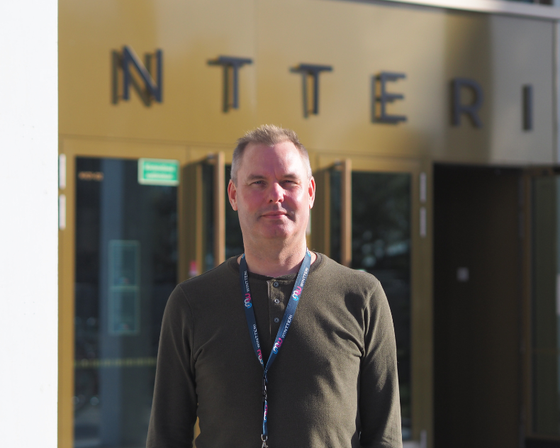 Petri Hatakka seisoo Wintterin edustalla, hymyilee ja katsoo kohti.