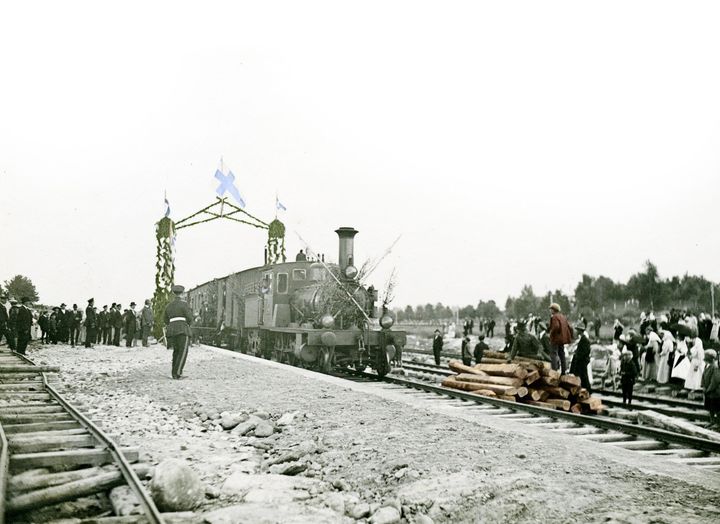 Vanha mustavalkoinen kuva höyryveturilla tomivasta junasta, joka saapuu Uuteenkaupunkiin.