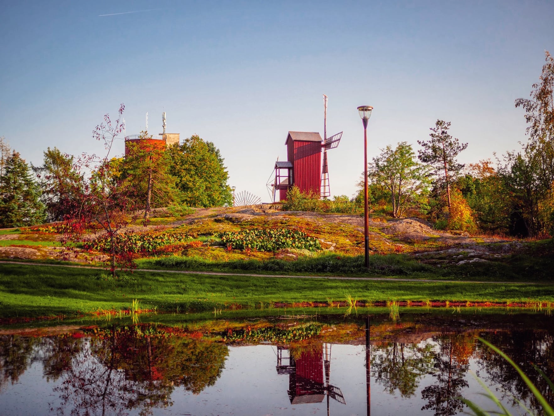 Upeat syvät värit alkusyksyn maisemassa Myllymäellä ja kaunis, punainen tuulimylly.